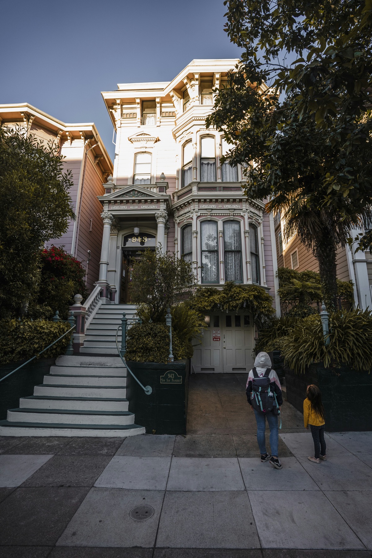 A caregiver and young child walking outside a San Francisco home